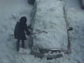 Девушка чистит снег с автомобиля железной лопатой.