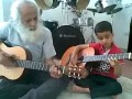 Внук и дед играют на гитарах (An Iranian kid plays guitar with his grandfather)